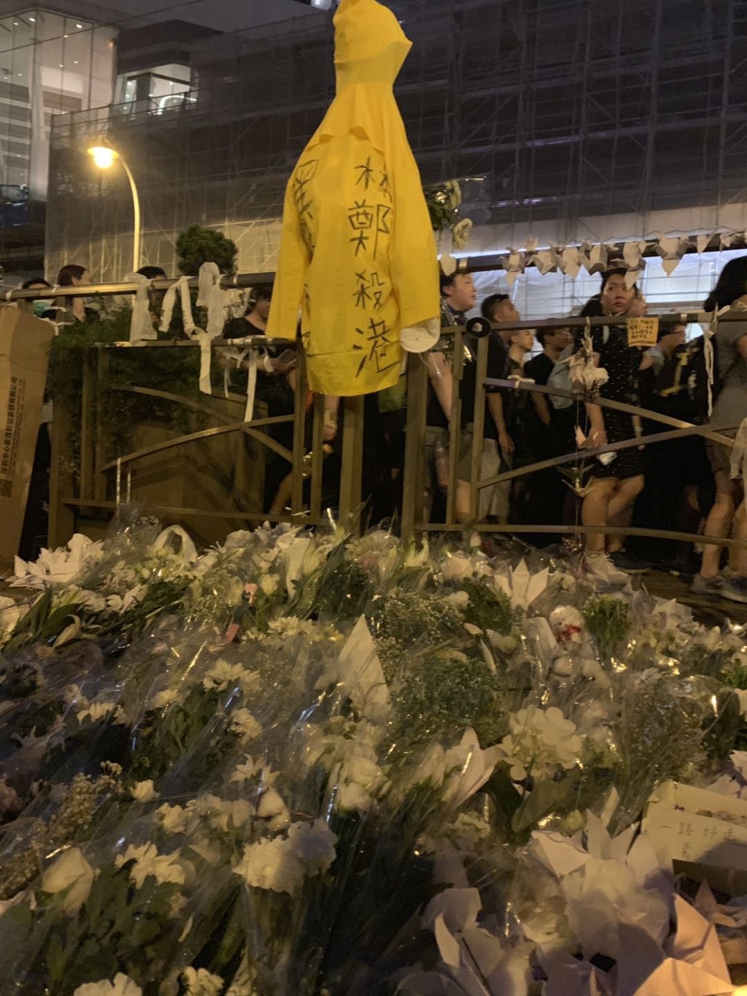 16일 전날 범죄인 인도 법안 개정에 반대하며 투신한 사고 현장. 고인이 입었던 노란 우비 앞으로 국화가 수북히 놓여있다. [신경진 기자]