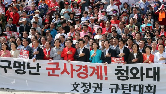 23일 서울 여의도 국회 본청 앞 계단에서 열린 '구멍난 군사경계! 청와대 은폐조작! 文정권 규탄대회'에서 황교안 자유한국당 대표, 나경원 원내대표, 조경태 최고위원을 비롯한 자유한국당 의원 및 당원들이 국민의례를 하고 있다. [뉴스1]