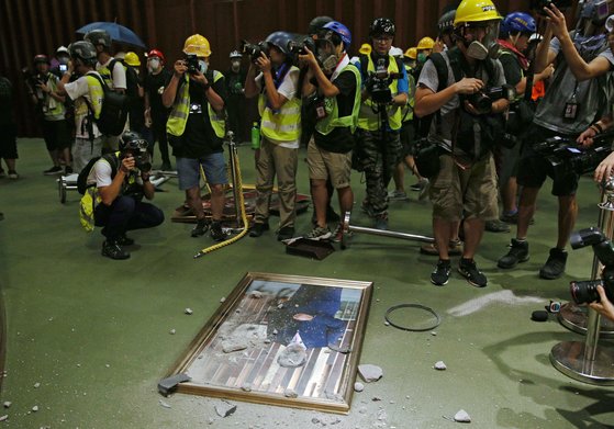 시위대가 앤드루 렁 입법회 의장의 초상을 바닥해 던져 훼손한 뒤 사진을 찍고 있다. [EPA]