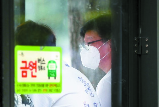 이날 서울 광화문광장 인근 정류장에서 미세먼지 마스크를 쓰고 버스를 기다리는 한 시민. [뉴시스]