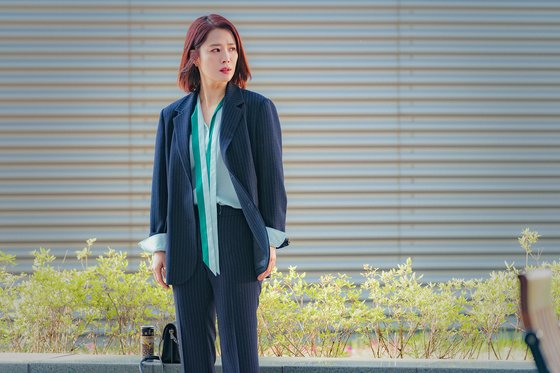 형사 사건 전문 변호사를 연기하는 배우 김현주는 딱딱해 보일 수 있는 남색 슈트에 초록색 리본 블라우스를 입어 여성스러움을 더했다. 이때 리본을 묶지 않고 풀어 세련된 이미지를 풍기는 스타일을 완성했다. [사진 OCN 왓쳐]