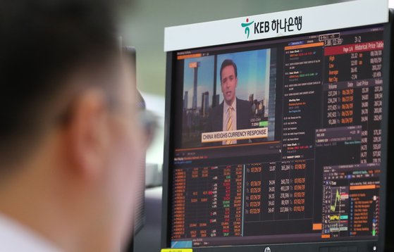 미국 재무부가 중국을 환율조작국으로 지정하며 미중 무역전쟁이 다시 심화되고 있는 6일 오전 서울 중구 KEB하나은행 딜링룸에 딜러가 위안화 관련 뉴스를 지켜보고 있다. [연합뉴스]