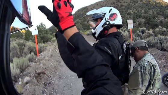 51구역 외곽 경계를 맡은 민간 경비회사 무장 경비원이 무단침입한 오토바이 운전자의 몸을 수색하고 있다. 이런 무단침입자는 링컨 카운티 보안관에게 넘겨진다.  [사진 유튜브 MACADVENTURES 계정 캡처]
