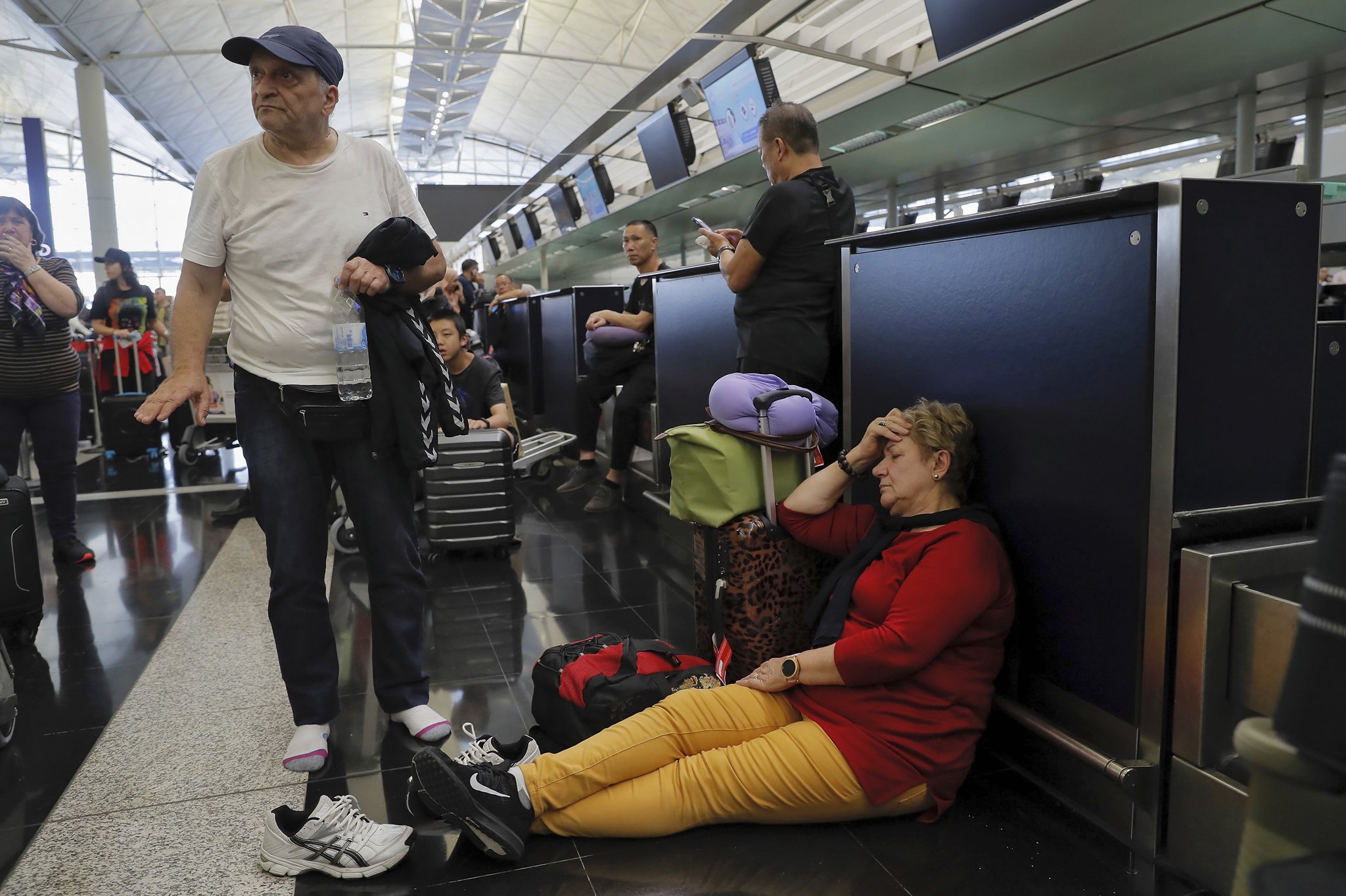 여행객들이 항공기 수속 창구가 운영을 중단하자 심각한 표정을 하고 있다. [AP=연합뉴스]