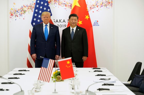 도널드 트럼프 미 대통령과 시진핑 중국 국가주석이 지난 6월 29일 일본 오사카에서 열린 미중 정상회담에 앞서 양국 국기를 앞에 두고 사진 촬영에 응하고 있다. [로이터=연합뉴스]
