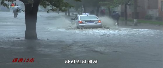 태풍 '링링'의 영향으로 폭우가 쏟아지고 있는 북한 사리원시에서 차량이 물에 잠긴 도로를 지나가고 있다. 사진은 중앙TV 방송화면 캡처.[연합뉴스]