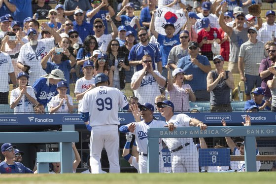 22일 메이저리그 첫 홈런을 치고 덕아웃으로 돌아온 류현진을 로버츠 감독(가운데)과 팬들이 환영하고 있다. [AP=연합뉴스]