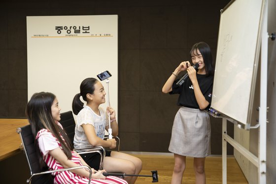 하람(오른쪽)이 중앙일보 사옥서 소중 학생기자단에게 특색있는 사진 촬영 비결을 공유하고 있다. 각자 셀카봉을 손에 든 학생기자단은 그에게 집중했다.