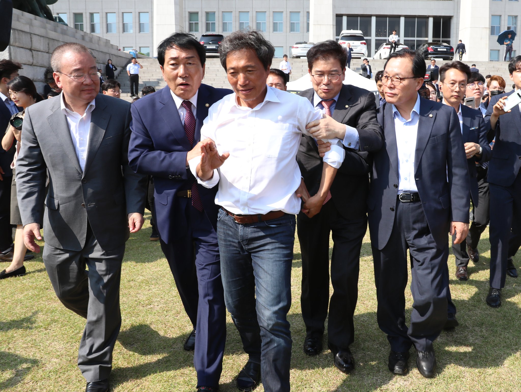 자유한국당 의원들이 건강 검진 받기를 만류하는 이 의원(가운데)을 구급차로 데려가고 있다. 김경록 기자