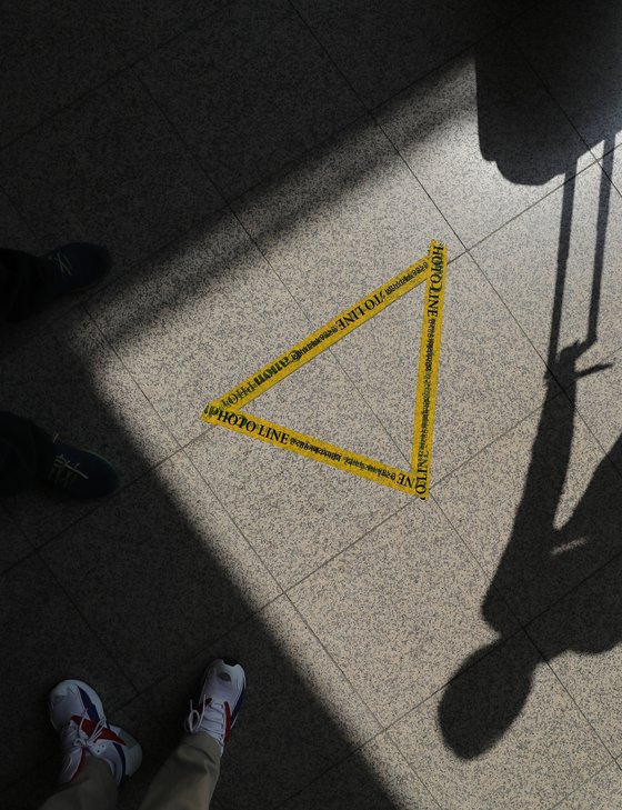 4일 오전 서울 서초구 서울중앙지검에 설치된 포토라인 위로 직원의 그림자가 비치고 있다. 조국 법무부 장관의 아내인 정경심 교수는 전날 검찰에 출석해 8시간 조사를 받았다. [연합뉴스]