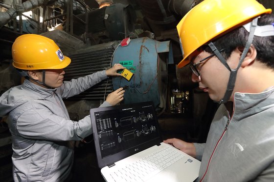 KT 연구원들이 대구의 한 제지공장에서 '기가사운드 닥터'를 생산 라인에 시험 적용하고 있다. [사진 KT]
