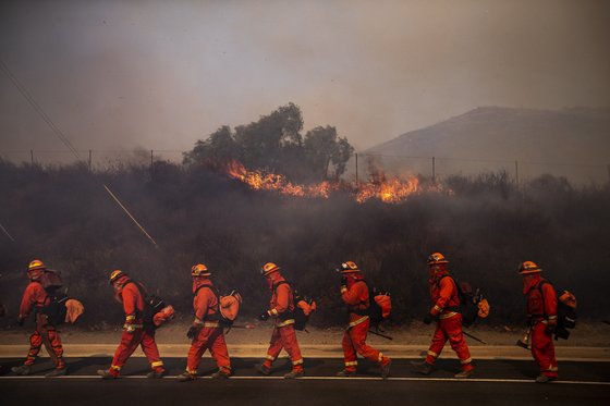 소방관들이 30일(현지시간) 캘리포니아 시미 밸리의 레이건 도서관 인근 화재 현장을 지나고 있다. [EPA=연합뉴스]