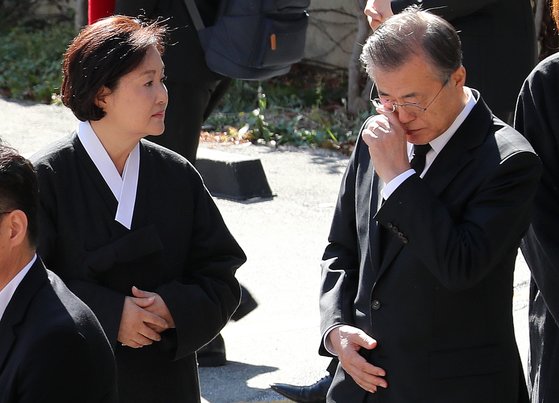 문재인 대통령이 31일 오전 부산 남천성당에서 어머니 고 강한옥 여사의 운구행렬 중 눈물을 닦고 있다. 왼쪽은 김정숙 여사. [뉴스1]