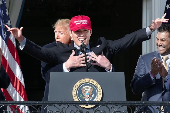 도널드 트럼프 미국 대통령이 지난 4일(현지시간) 올해 월드시리즈 우승팀인 워싱턴 내셔널스 선수들을 백악관으로 초청했다. 이날 팀의 포수 커트 스즈키가 준비해 온 ‘미국을 다시 위대하게’ 모자를 쓰자 트럼프 대통령이 뒤에서 포옹하고 있다. [EPA=연합뉴스]