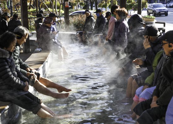 대전 유성구 유성온천 족욕체험장을 찾은 시민들이 따뜻한 온천수에 발을 담그고 몸을 녹이고 있다. [뉴스1]