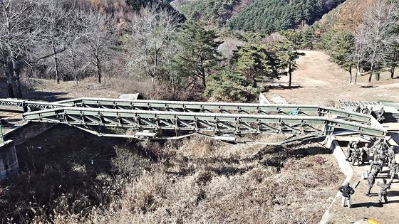 교량대대 장병이 계곡 사이에 간편조립교를 구축하고 있다. 영상캡처 = 공성룡 기자