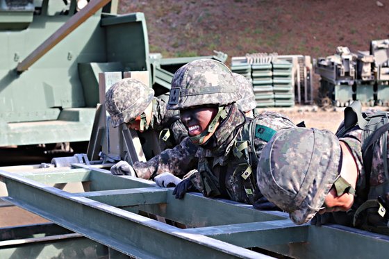 김동우 소위와 병사가 간편조립교를 부품을 힘차게 밀고 있다. 박용한