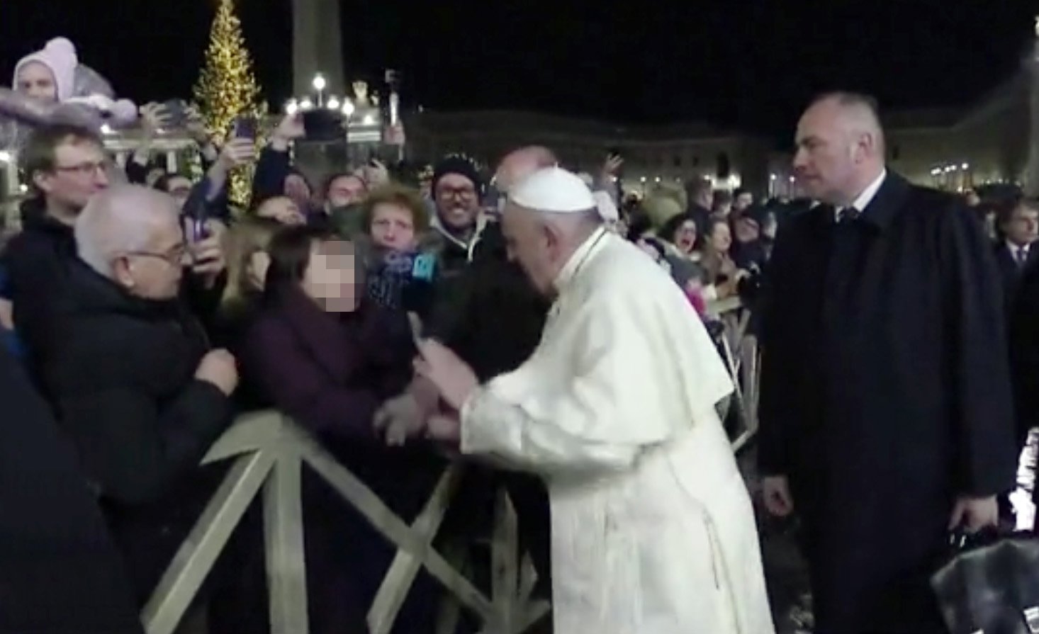 한 여성이 지난해 12월 31일 바티칸 성 베드로 광장에서 프란치스코 교황의 손을 잡아 당기자 교황이 통증을 호소하며 여성의 손을 치고 있다. [ 사진 바티칸미디어 동영상 캡처]