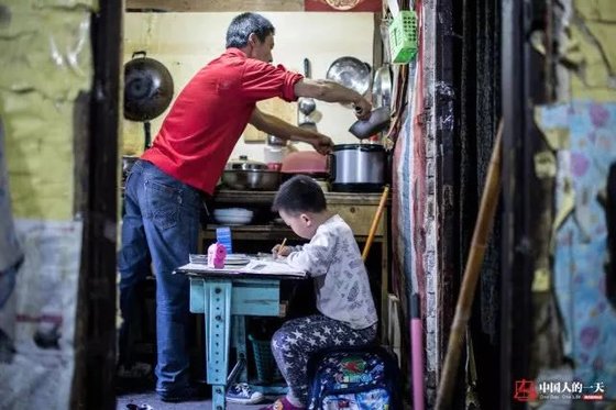 란광후이의 아들은 판자촌 거주 시절 부엌 등불 아래 숙제를 해야 했다. [중국 인민망 캡처, 쉬캉핑]