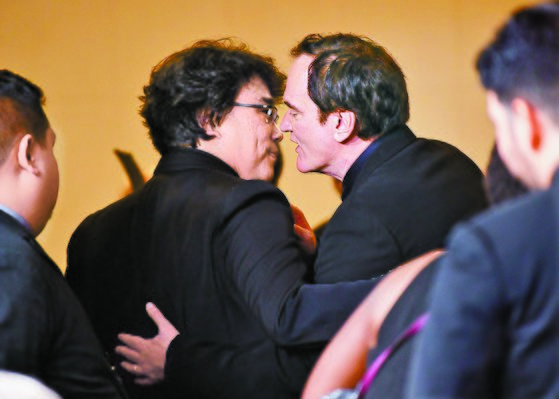 골든글로브 시상식장에서 봉준호 감독과 쿠엔틴 타란티노 감독이 귓속말을 나누고 있다. [AFP=연합뉴스]