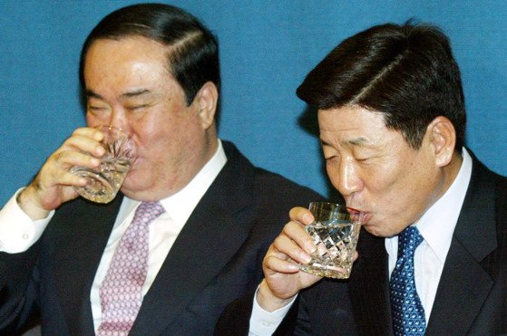 2004년 당시 문희상 전 대통령 비서실장(왼쪽)과 유인태 전 정무수석이 청와대 춘추관에서 총선 출마 기자간담회를 하던 도중 물을 마시고 있다. [중앙포토]