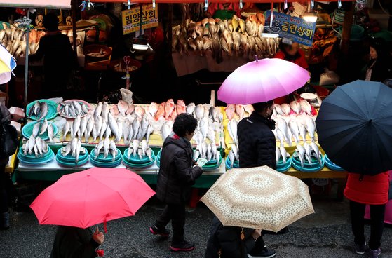 겨울비가 내리는 22일 부산 중구 자갈치시장에서 시민들이 제수용품을 구입하고 있다. [연합뉴스]