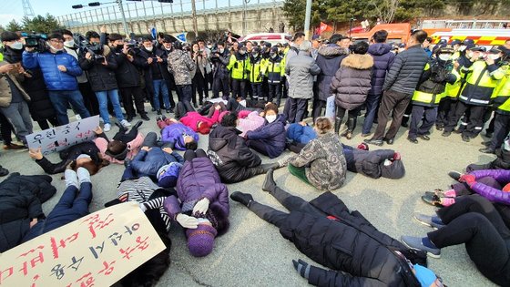 30일 오후 중국 우산 교민을 격리 수용할 시설인 충남 아산시 경찰인재개발원 앞에서 주민들이 정부의 결정을 수용할 수 없다며 도로에 누워 항의하고 있다. 프리랜서 김성태