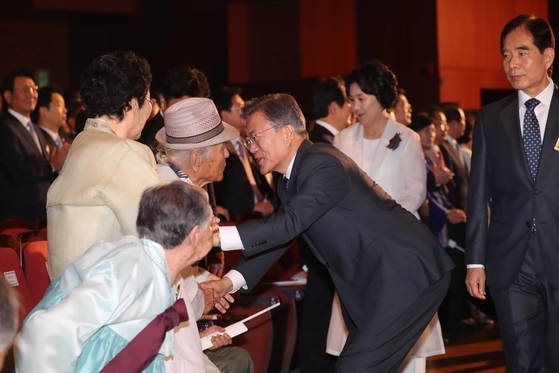 문재인 대통령이 2017년 8월 15일 오전 세종문화회관에서 열린 제72주년 광복절 경축식에 참석하며 일본군 위안부 및 강제징용 피해자들과 인사하고 있다. [연합뉴스]