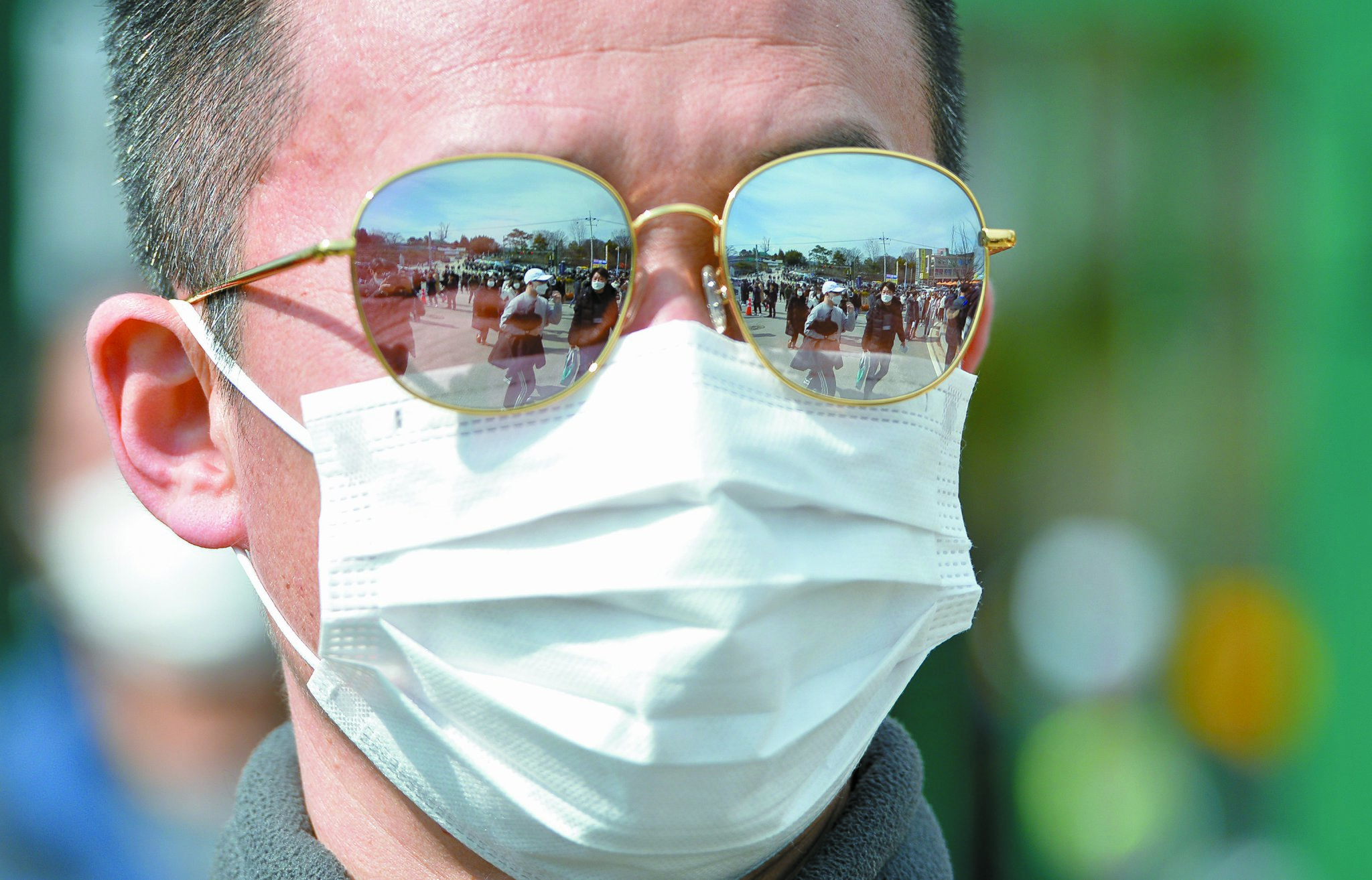 신종 코로나 바이러스 감염증(코로나19) 확진자가 전국 곳곳으로 확산되면서 군 당국도 비상에 걸렸다. 지난달 24일 충남 논산 육군훈련소 입구에서 배웅온 한 아버지의 선글라스에 마스크를 착용한 입소 장병들의 모습이 반영되고 있다. 프리랜서 김성태