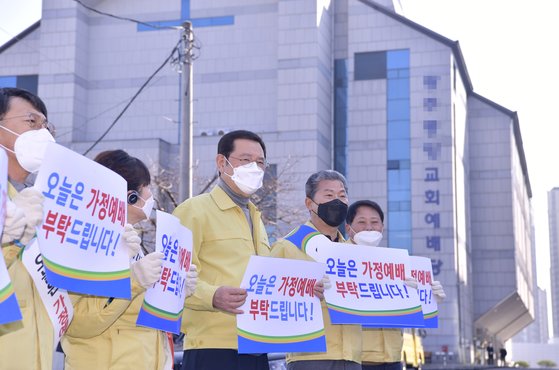 이용섭 광주시장이 8일 서구 한 교회 정문 앞에서 서대석 서구청장 및 직원들과 함께 코로나19 집단 감염 방지를 위해 집단 예배 자제를 호소하고 있다. 뉴스1
