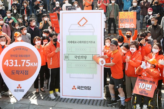 안철수 국민의당 대표가 14일 오후 서울 종로구 세종문화회관 앞에서 열린 '통합의 국민보고 기자회견'에서 대형 투표용지에 도장을 찍는 투표 독려 퍼포먼스를 하고 있다.<br><br>[뉴스1]