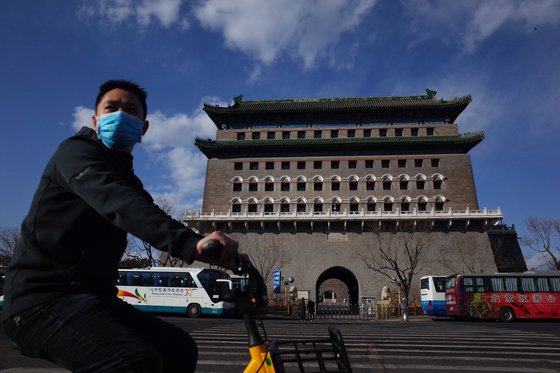 지난달 1일 중국 베이징의 치안먼 앞을 마스크를 쓴 시민이 자전거를 타고 지나고 있다. 미세먼지가 없는 맑은 하늘이다. EPA=연합뉴스