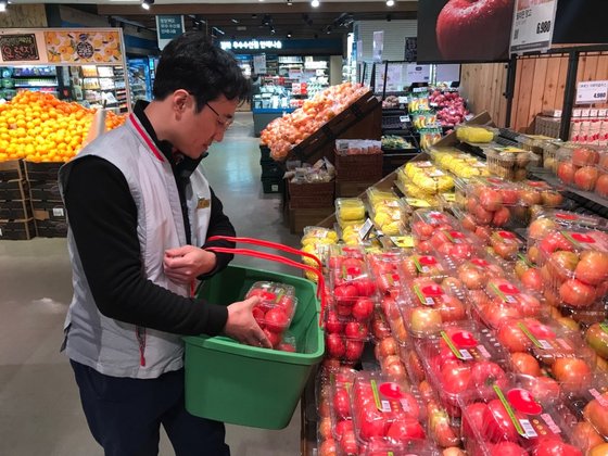 주문부터 배송기사가 택배차에 상품을 넣고 출발하기까지 30분 안팎이 소요된다. 실제 배송까지 1시간이 걸렸다. 고객이 앱으로 주문한 토마토를 롯데마트 직원이 담고 있다.