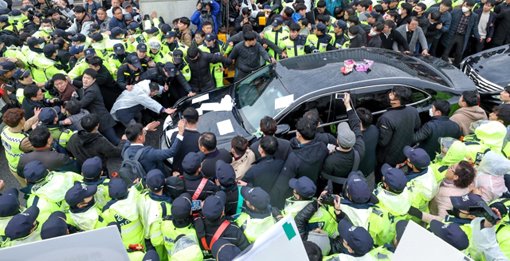 11일 전두환 전 대통령이 5·18 민주화운동 관련 형사재판 출석을 마치고 광주지방법원을 빠져나가자 시민들이 차량을 둘러싸며 사죄를 촉구하고 있다. [연합뉴스]