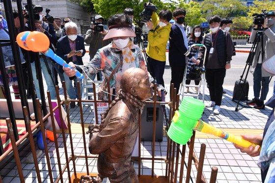 5?18 피해자 유가족들이 27일 광주광역시 동구 광주지방법원 앞에서 전두환 전 대통령의 법정 출석을 앞두고 장난감 망치로 흉상을 내려치고 있다. 프리랜서 장정필