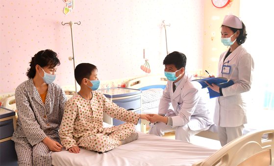 북한 평양의 옥류아동병원에서 의료진이 입원 중인 어린이 환자 및 보호자와 이야기를 나누고 있다. 모두 마스크를 착용하고 있는 점이 눈길을 끈다. [우리민족끼리 홈페이지 캡처]