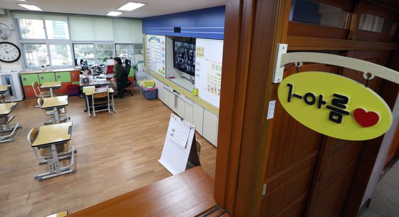 신종 코로나바이러스 감염증(코로나19) 확산 예방 차원에서 ‘온라인 개학‘을 한 지난 20일 서울 용산구 용산초등학교 1학년 교실에서 교사가 원격으로 입학식을 진행하고 있다. 뉴스1