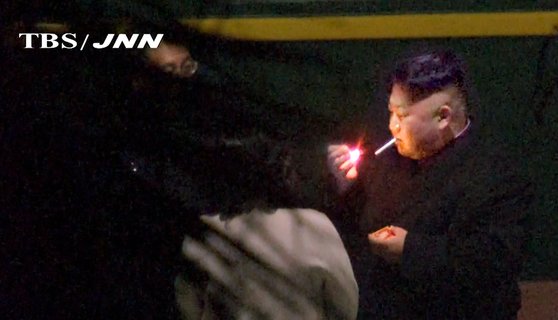 지난 2019년 2월 26일 새벽 일본 TBS TV가 촬영한 영상에서 김정은 북한 국무위원장은 도널드 트럼프 대통령과 2차 북미회담을 위해 특별열차를 타고 베트남에 도착하기 전 중국 난닝의 기차역에 잠시 하차해 담배를 피고 있다. [AP=연합뉴스]