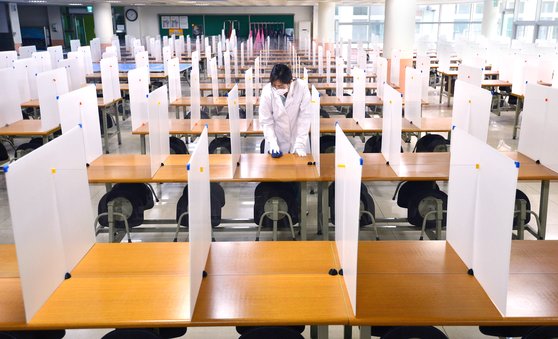 신종 코로나바이러스 감염증(코로나19) 확산세가 주춤하면서 정부가 단계적인 등교 개학을 검토하고 있는 지난 4일 오후 대구 중구 남산동 경북여자고등학교 급식실에서 선생님이 투명 칸막이가 설치된 비대면 급식실을 소독하고 있다. 뉴시스