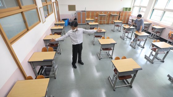 신종 코로나바이러스 감염증(코로나19) 확산 세가 주춤하면서 정부가 단계적인 등교 개학을 검토하고 있는 가운데 지난 4일 서울 양천구 금옥여자고등학교에서 선생님들이 교실 책상 간격을 벌리고 있다. 뉴스1
