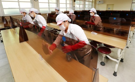 11일 대전 중구 충남여자고등학교 급식실에서 조리사들이 설치된 칸막이를 소독하고 있다. 뉴스1