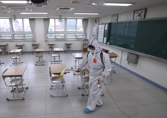 서울 이태원 클럽발 신종 코로나바이러스 감염증(코로나19) 집단 감염으로 학교들의 등교 재연기가 발표된 지난 11일 오후 서울 성동구 성수고등학교 3학년 교실에서 방역업체 관계자가 교실 소독을 하고 있다. 연합뉴스