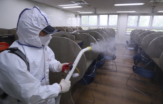 서울 이태원 클럽발 신종 코로나바이러스 감염증(코로나19) 집단 감염으로 학교들의 등교 재연기가 발표된 지난 11일 오후 서울 성동구 성수고등학교 자습실에서 방역업체 관계자가 소독을 하고 있다. 연합뉴스