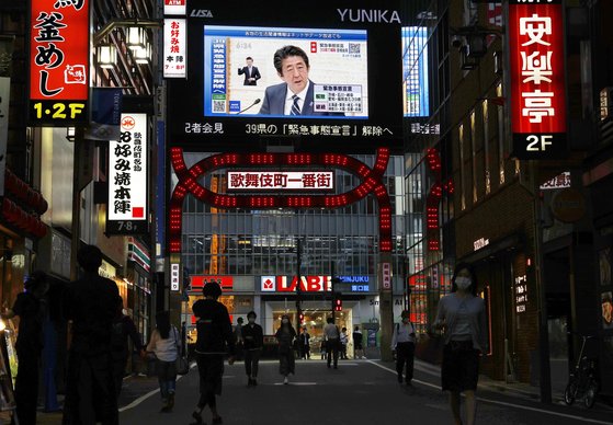 아베 신조(安倍晋三) 일본 총리가 14일 오후 도쿄 관저에서 기자회견을 열어 신종 코로나바이러스 감염증(코로나19) 대응을 위해 전국에 선포했던 긴급사태의 부분 해제를 발표했다. 사진은 아베 총리의 기자회견이 도쿄 신주쿠(新宿) 거리의 대형 비전을 통해 중계되고 있는 모습. [교도=연합뉴스]