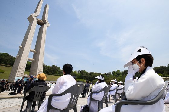 5·18 민주화운동 40주년 기념식을 하루 앞둔 17일 오전 광주 북구 망월동 국립 5·18 민주묘지에서 열린 추모제에 참석한 유족들이 코로나19 확산을 막기 위해 1m 이상 거리를 띄운 채 자리에 앉아 있다. 프리랜서 장정필