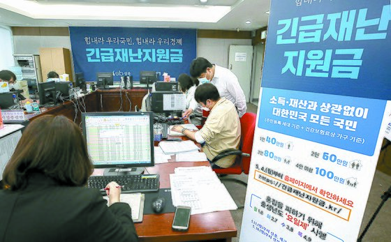 12일 서울 성북구청에서 직원들이 긴급재난지원금 신청과 관련해 안내, 상담을 하고 있다.연합뉴스