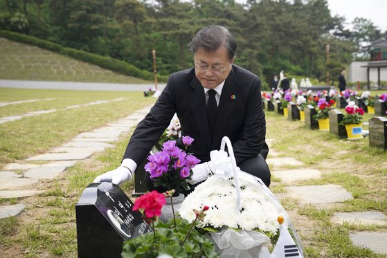 문재인 대통령이 제40주년 5·18 민주화운동 기념일인 18일 광주 북구 5·18 민주묘지 제2묘역에서 고(故) 이연 씨 묘를 찾아 묘비를 어루만지고 있다.   고인은 전남대 1학년에 재학 중이던 1980년 5월 27일 YMCA 회관에서 계엄군과 총격전 중 체포되어 전신 구타를 당했다. [연합뉴스]