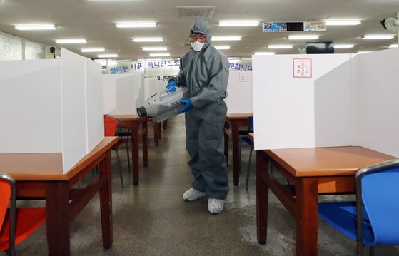 고등학생 3학년 등교를 하루 앞둔 19일 오전 광주 북구 살레시오고등학교 코로나19 예방 칸막이가 설치된 급식실에서 광주 북구청 방역반원들이 방역하고 있다. 연합뉴스