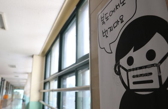 고3 등교 개학을 하루 앞둔 19일 오후 서울 경복고등학교 복도에 마스크 착용을 당부하는 안내문이 붙어있다. 연합뉴스
