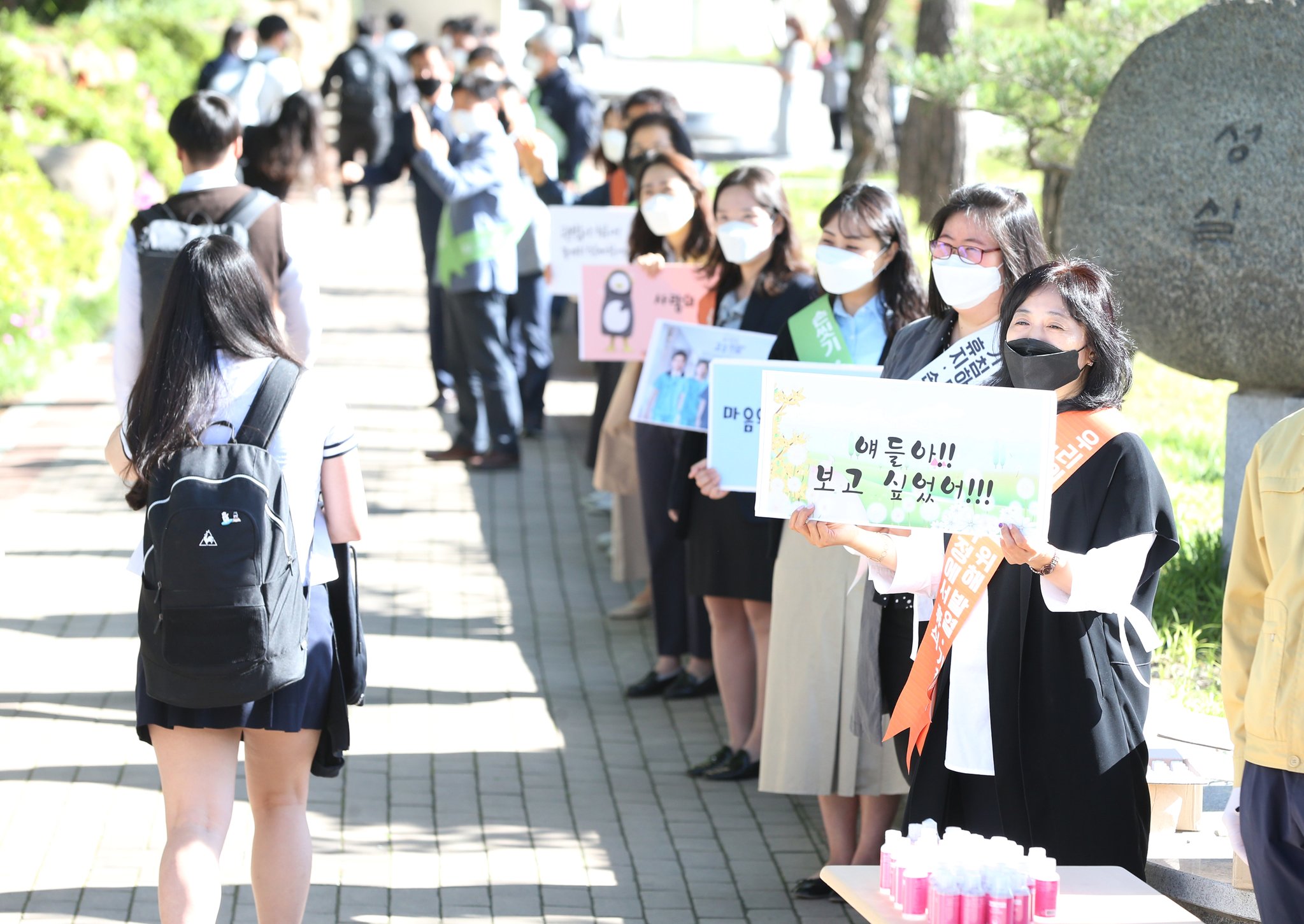 20일 코로나19로 집에서 수업을 받던 경북 포항 영일고 3학년 학생들이 처음으로 등교하자 교사들이 "얘들아 보고 싶었어"라고 쓴 손팻말을 들고 환영하고 있다. 연합뉴스